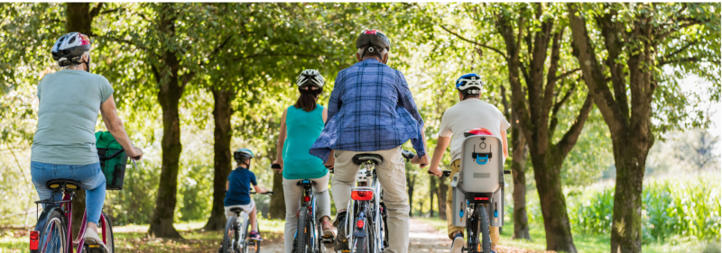 riteņbraucēji brauc pa parku
